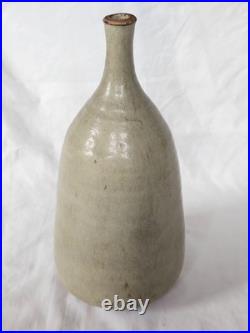 A tall celadon studio pottery sculptural vase, with potter's mark