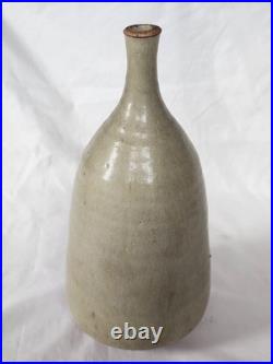 A tall celadon studio pottery sculptural vase, with potter's mark