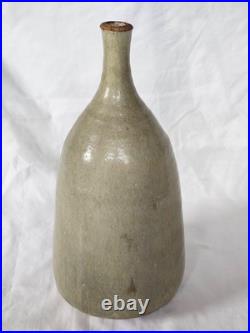 A tall celadon studio pottery sculptural vase, with potter's mark